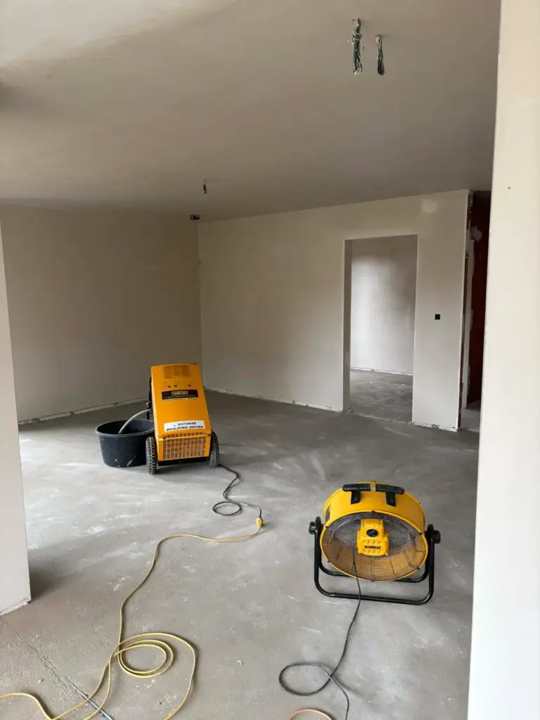 Dryfast DF800F bouwdroger met opvangkuip en ventilator op het gelijkvloers van een nieuwbouw in Diepenbeek